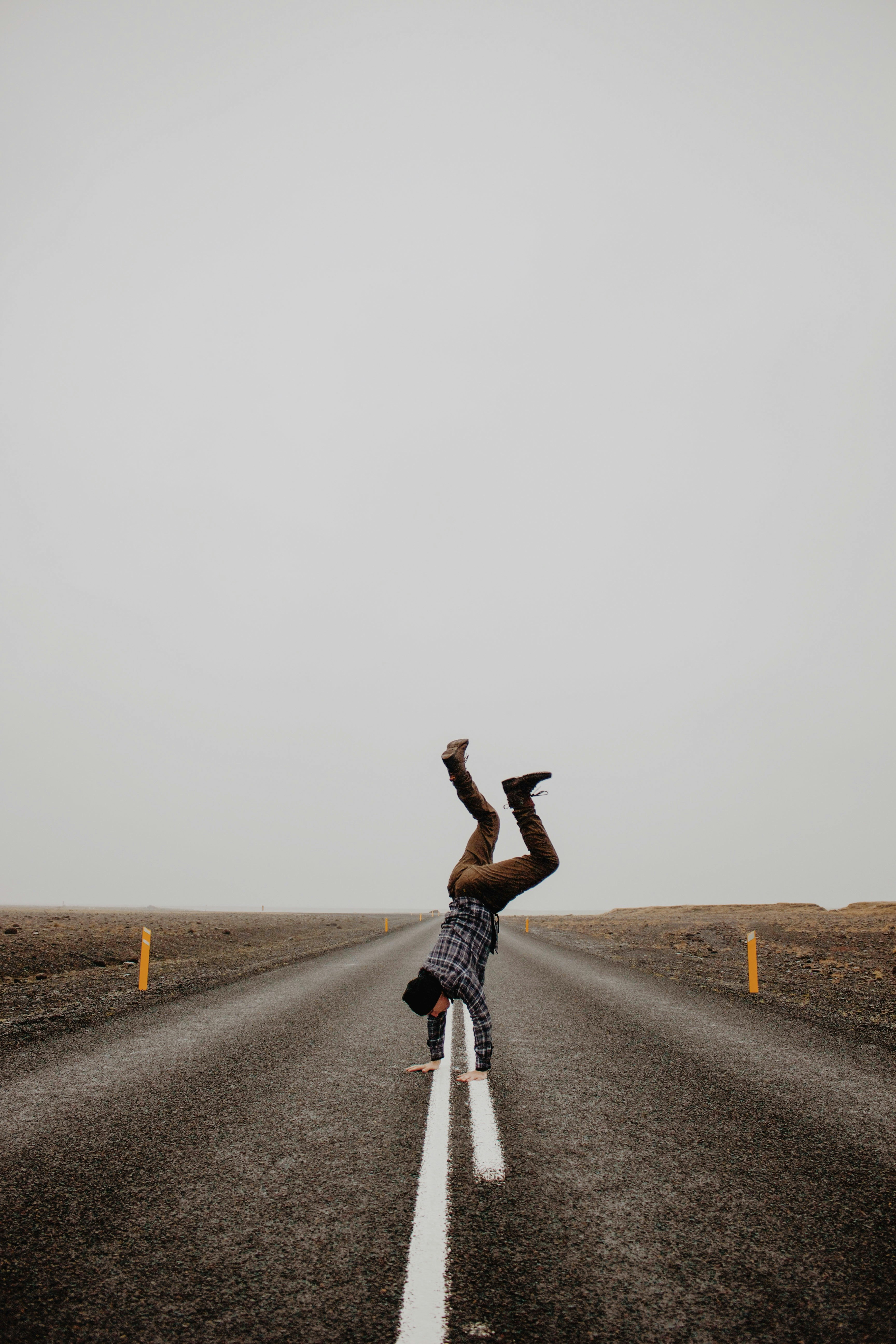 person hand standing on road during daytime